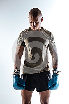 Brawny sportive boxer wearing sport suit and boxing gloves