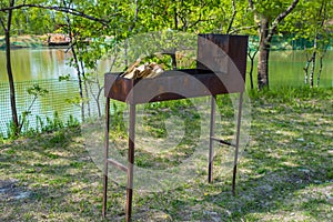 Brazier with firewood on the background of the river photo