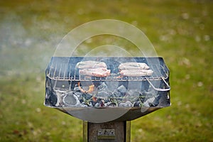 A brazier and four steaks on the grill