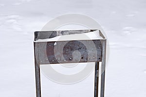 Brazier in the winter outdoors in the forest covered with snow