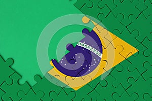 Brazil flag is depicted on a completed jigsaw puzzle with free green copy space on the left side