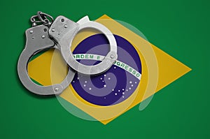 Brazil flag and police handcuffs. The concept of crime and offenses in the country photo