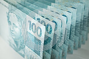 Brazil money, Stack of 100 reais banknotes standing in harmony vertically on the table, Business concept photo