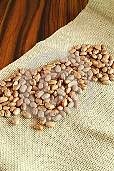 Brazilian beans. Carioca beans on the jute fabric on the rustic wooden table photo