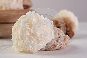 Brazilian cocada coconut candy in close up placed in a wooden pot on a table with white towel, selective focus