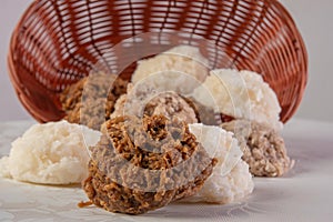 Brazilian cocada coconut candy dropped from a basket on a table with white towel, selective focus