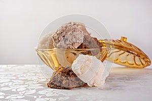 Brazilian cocada coconut candy placed in a glass jar on a table with white towel, selective focus