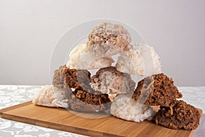 Brazilian cocada coconut candy placed on a polished board on a table with white towel, selective focus