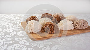 Brazilian cocada coconut candy placed on a polished board on a table with white towel, selective focus