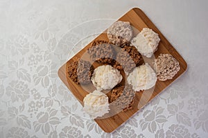 Brazilian cocada coconut candy placed on a polished board on a table with white towel, top view