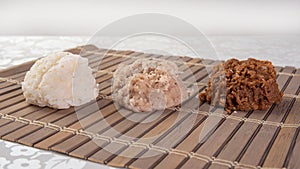 Brazilian cocada coconut candy placed on a wooden mat on a table with white towel, selective focus