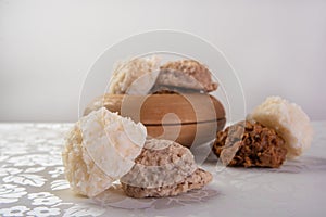 Brazilian cocada coconut candy placed in a wooden pot on a table with white towel, selective focus