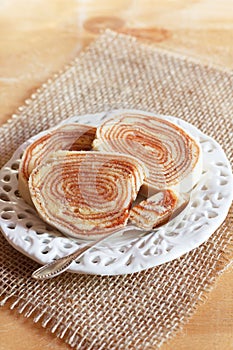 Brazilian dessert Bolo de rolo (swiss roll, roll cake) on white