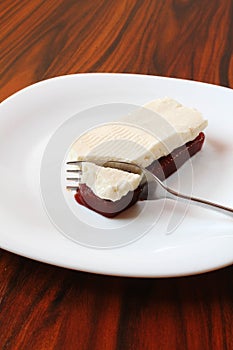 Brazilian dessert, guava paste and white chesse with fork on the white plate.