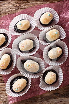 Brazilian dessert sweets Olho de sogra from condensed milk, prunes and coconut close-up. Vertical top view photo