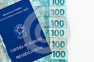 Brazilian document work and social security Carteira de Trabalho e Previdencia Social with Brazilian money banknotes