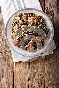 Brazilian Feijao Tropeiro traditional dish, made with beans, bacon, sausage, collard greens, eggs and manioc flour. Vertical top photo