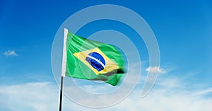 Brazilian flag waving against blue sky