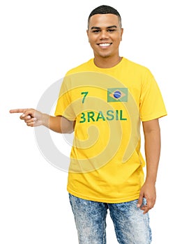Brazilian foorball fan with yellow jersey pointng sideways
