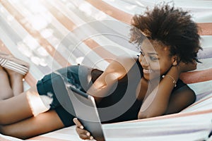 Brazilian girl with digital pad on hammock