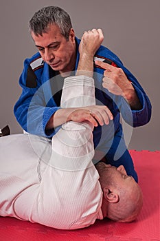 Brazilian jiu jitsu instructor demonstrates ground fighting arm
