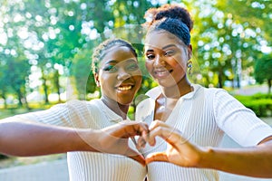 brazilian lesbian couple in white dress spending time together celebrating engagement in summer park outdoor