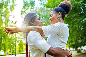 brazilian lesbian couple in white dress spending time together celebrating engagement in summer park outdoor