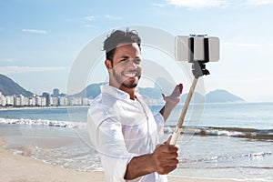 Brazilian man making Selfie with a stick at Copacabana beach