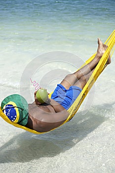 Brazilian Man Relaxing in Beach Hammock with Drinking Coconut
