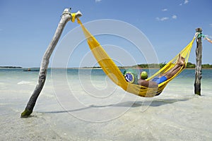 Brazilian Man Relaxing in Beach Hammock with Drinking Coconut