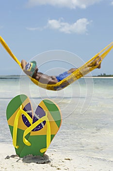 Brazilian Man Relaxing in Beach Hammock Over Sea