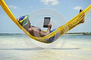 Brazilian Man Relaxing with Tablet in Beach Hammock