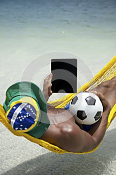 Brazilian Man Relaxing with Tablet and Football Beach Hammock