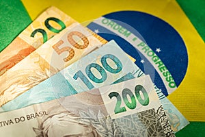 Brazilian money on the background of the national flag, Symbols of Brazil, Economic concept