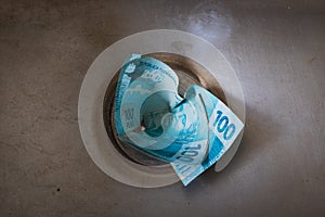 Brazilian money wet down the drain. Bad Brazilian Real economy concept image. Space for text