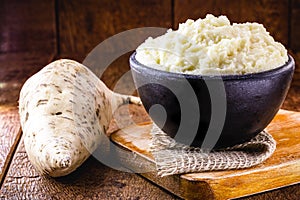 Brazilian potato cream, called `mashed potato`, with potatoes and sour cream in the background.