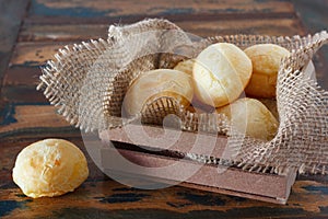 Brazilian snack cheese bread (pao de queijo) in wooden box with photo