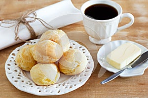 Brazilian snack pao de queijo (cheese bread) white plate butter