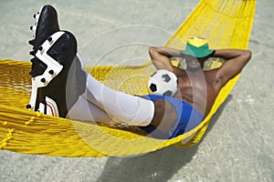 Brazilian Soccer Player Relaxes with Football in Beach Hammock