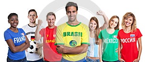 Brazilian soccer supporter with crossed arms and fans from other