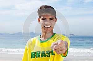 Brazilian sports fan at beach pointing at camera