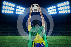 Brazilian supporter holding a ball at field