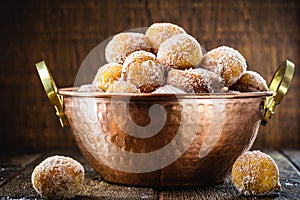 Brazilian sweet called Bolinho de Chuva, made with cinnamon, refined and fried sugar. Food served in a copper pot, typical sweet photo
