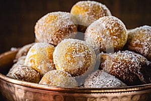 Brazilian sweet called Bolinho de Chuva, made with cinnamon, refined and fried sugar. Food served in a copper pot, typical sweet photo