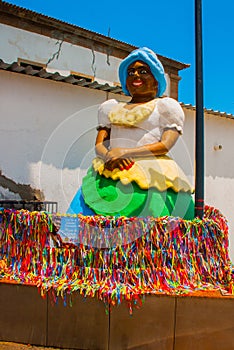 Brazilian woman of African descent, smiling, dressed in traditional Baiana attire in Pelourinho, Salvador, Brazil