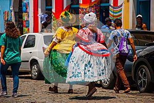 Brazilian woman of African descent, smiling, dressed in traditional Baiana attire in Pelourinho, Salvador, Brazil