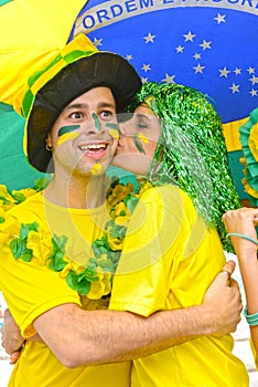 Brazilian woman soccer fans commemorating victory kissing.