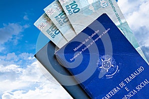 Brazilian Work Card with Brazilian money isolated on blue sky and clouds background. Written in Portuguese Federative Republic of