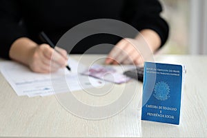 Brazilian work card and social security blue book lies on accountant or boss table