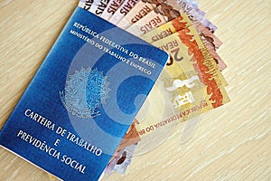 Brazilian work card and social security blue book and reais money bills